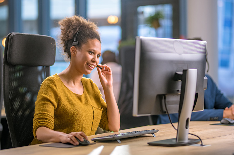 woman sitting at a desk and looking at a computer