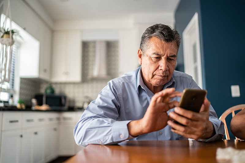 Man at a table using his cell phone