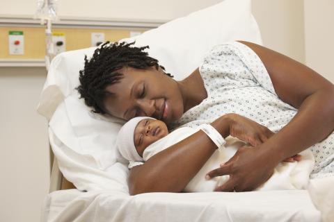 Mother holding her newborn in a hospital bed