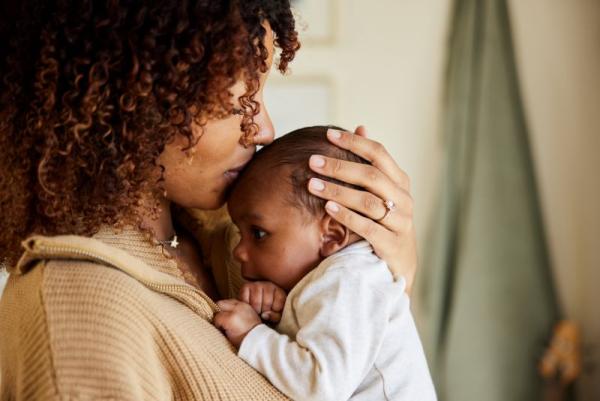 Mother kissing her child.